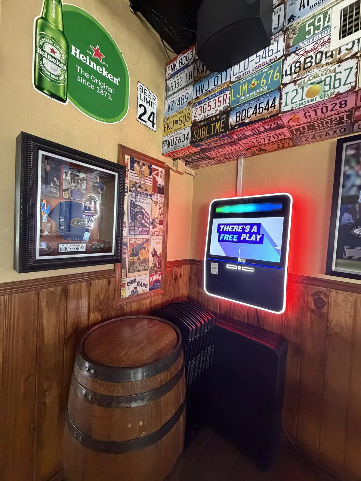 Sports screens and license plate wall above the high-top tables